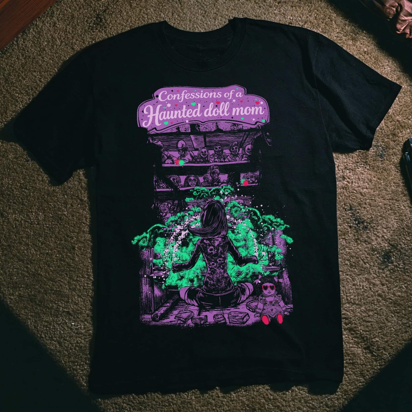 Front view of SleepOver x Confessions of a Haunted Doll Mom t-shirt featuring haunted doll ritual artwork in purple and green paranormal illustration.