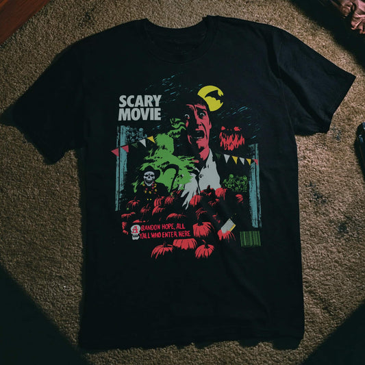 Black t-shirt with a vintage horror movie poster-style graphic reading 'Scary Movie,' featuring a screaming man's face, a yellow crescent moon, dancing skeletons, a pumpkin patch, and the text 'Abandon Hope, All Y'all Who Enter Here.